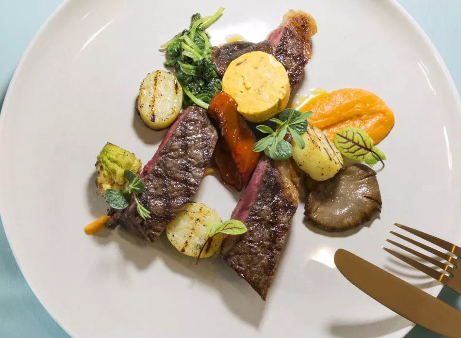 Rubia Gallega gerijpt, crème van zoete aardappel, tatsoi, gegrilde krieltjes en beurre Café de Paris