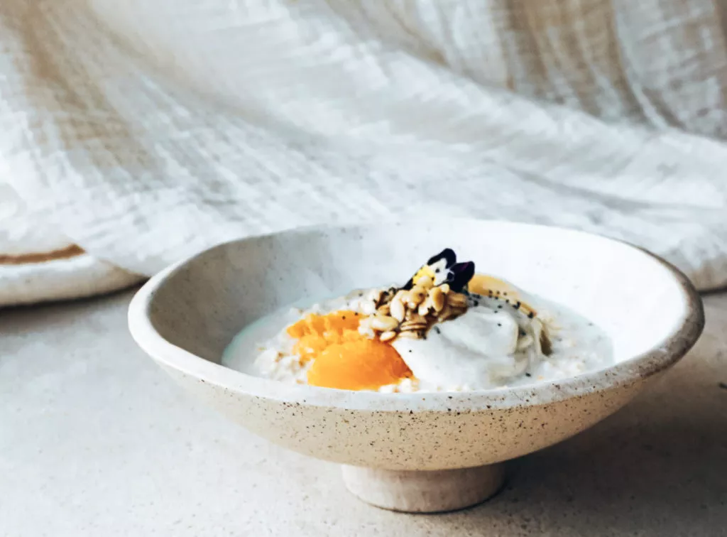 Gefermenteerde havermout met kweeperenpuree, oranjebloesemyoghurt en citrusvruchten