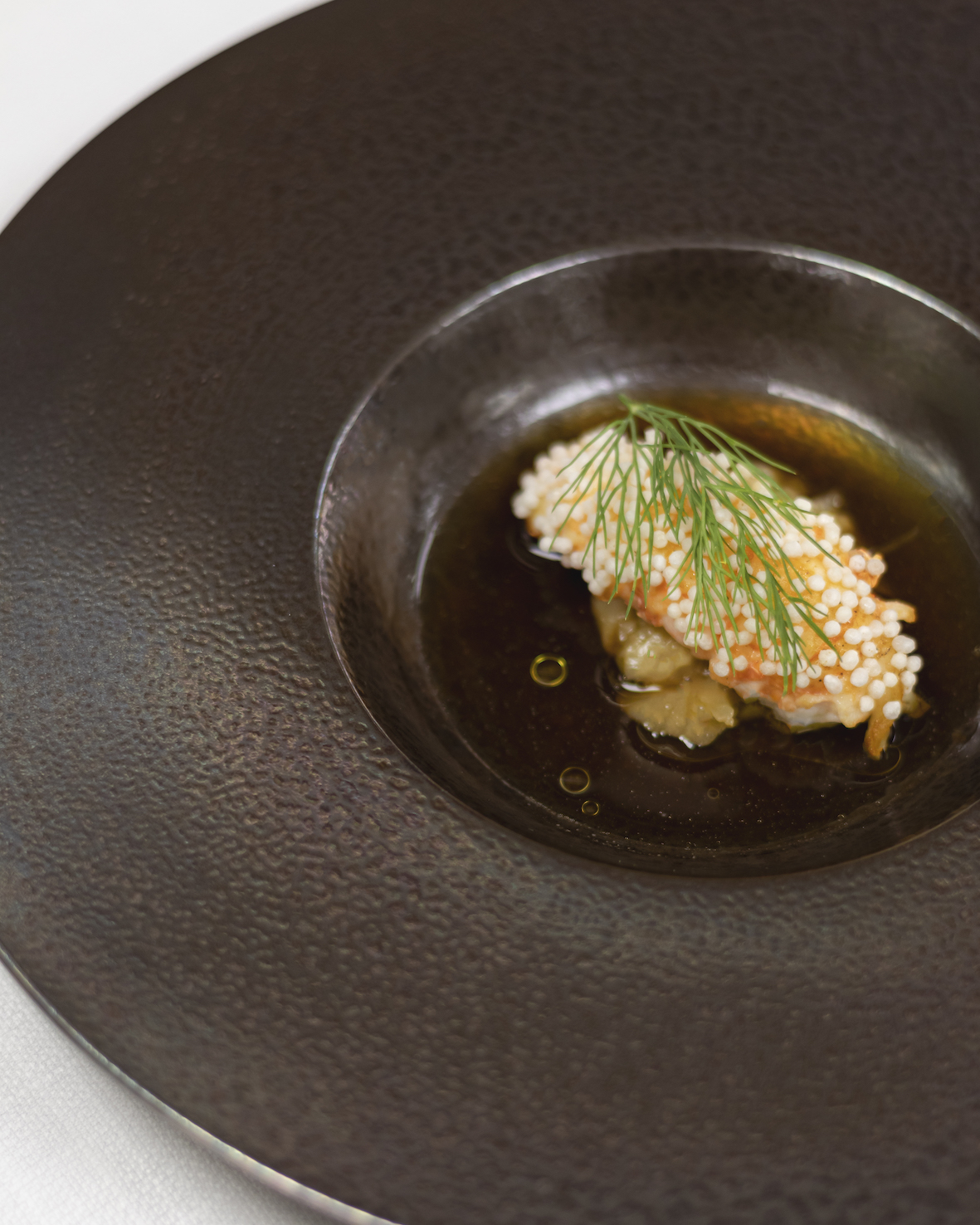 Noorse langoustine met zuurkool, witte bonen & consommé van boschampignons