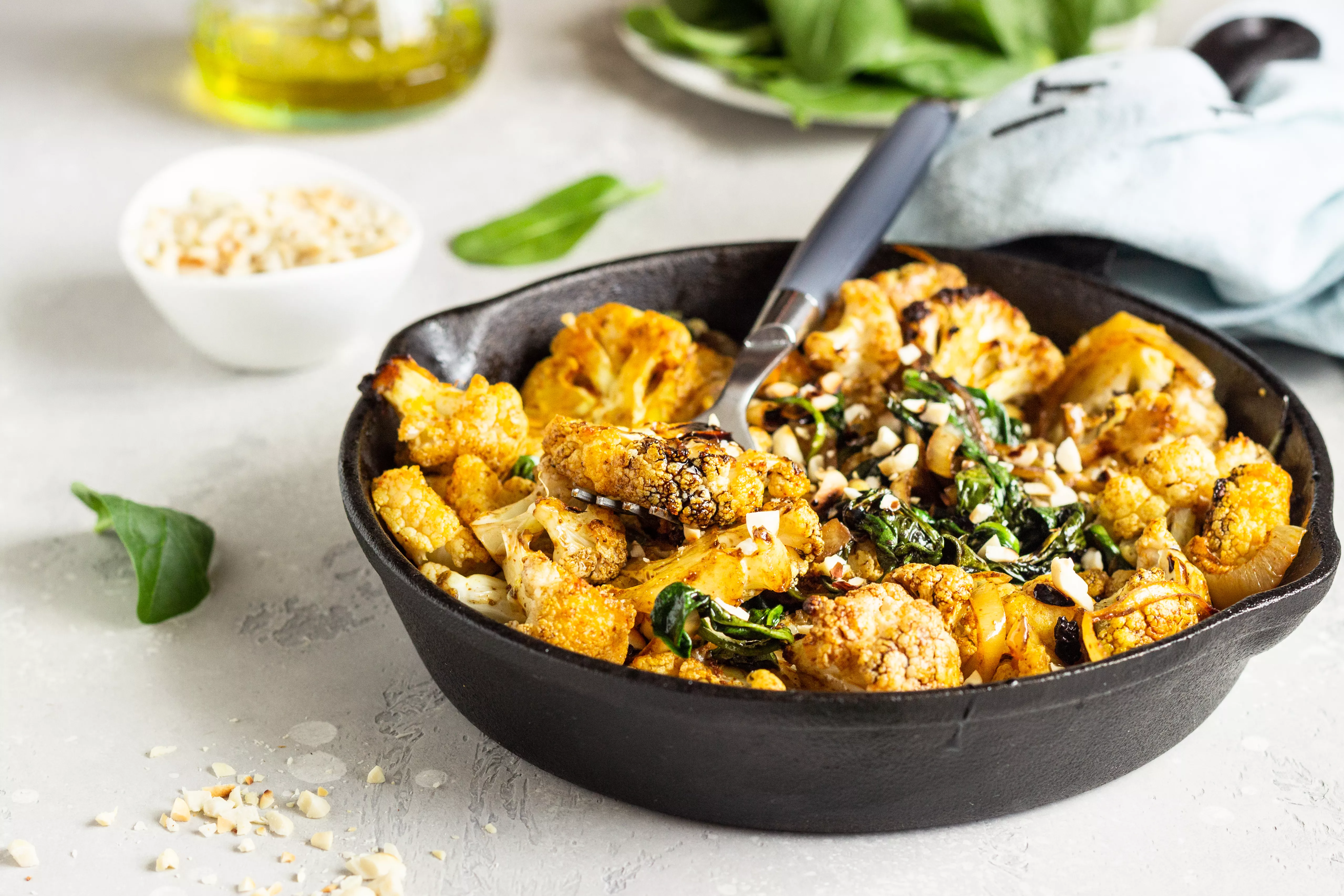 Indiase curry met geroosterde bloemkool, noten en spinazie