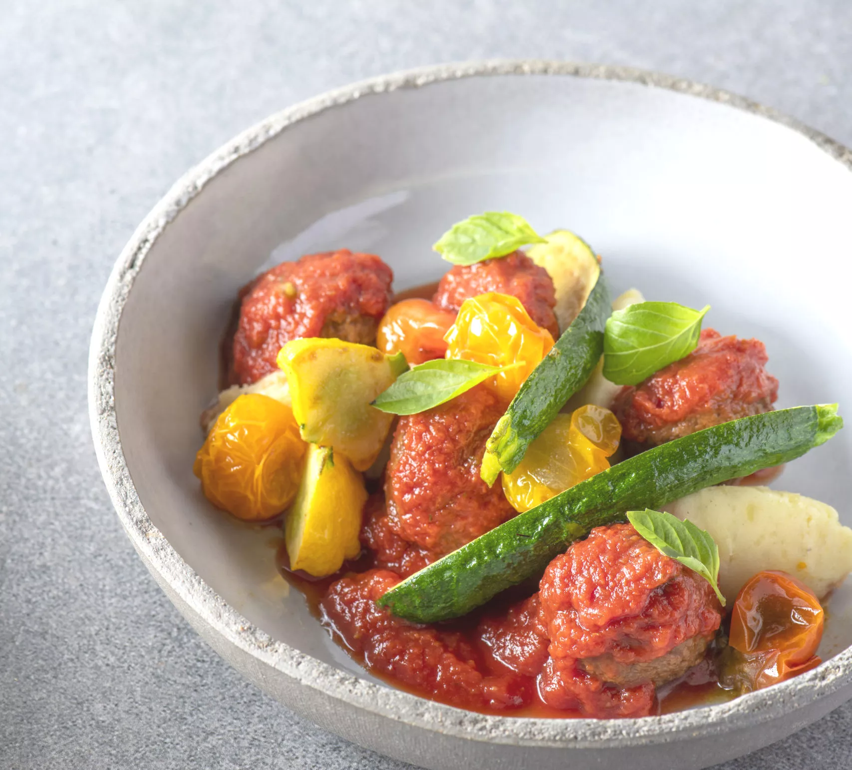 Gehaktballen met mini-courgettes, gele tomaten en patisson