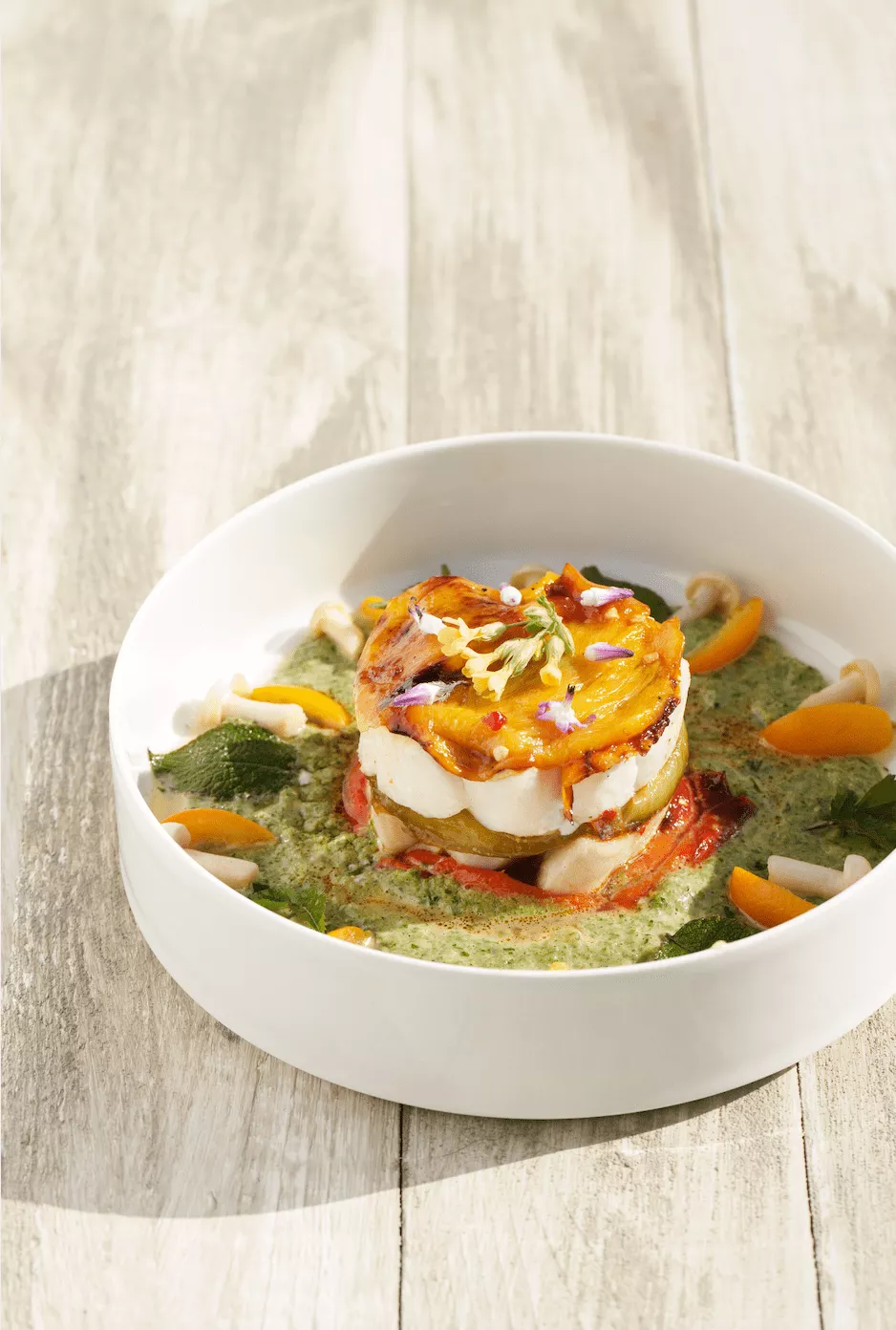 Millefeuille van paprika in 3 kleuren en schelvis, een coulis van groene kruiden en gefermenteerde kumquat